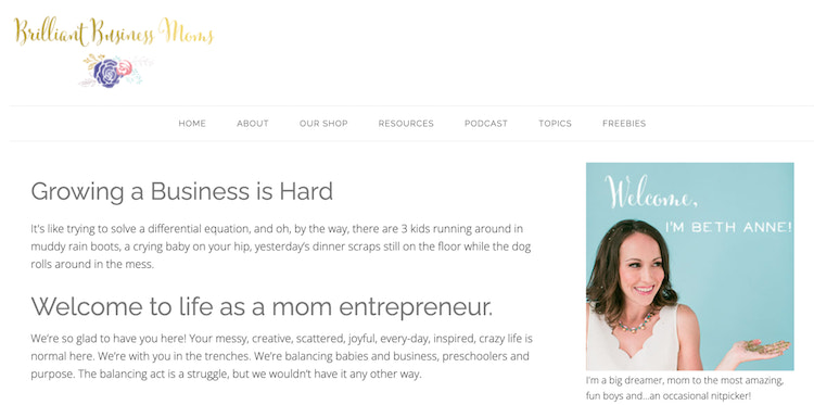 Brilliant Business Moms的“About”页面右侧是一位女士,她穿着扇形上衣,左手掌心朝天