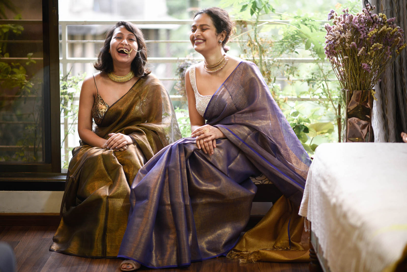 Sujata和Taniya穿着纱丽微笑着。