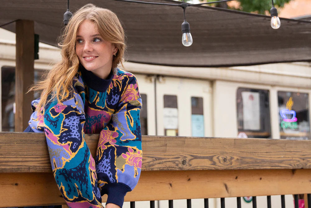 一个穿短夹克的女人斜靠在栅栏上