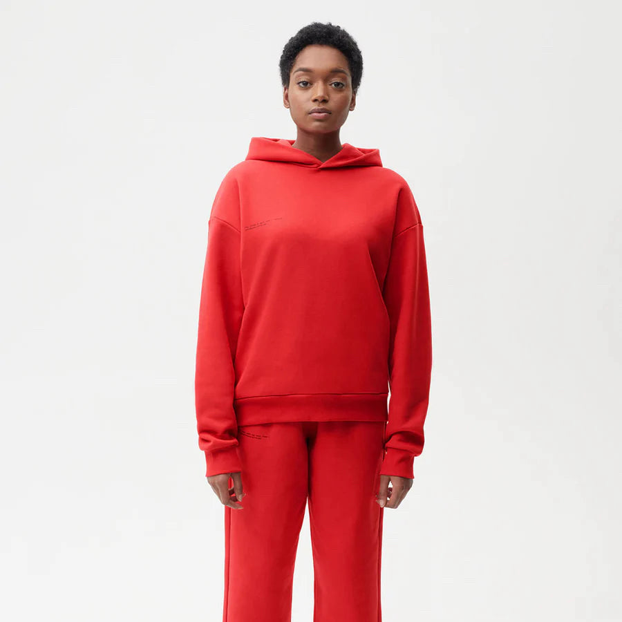 A model wears a red sweatsuit against a plain background