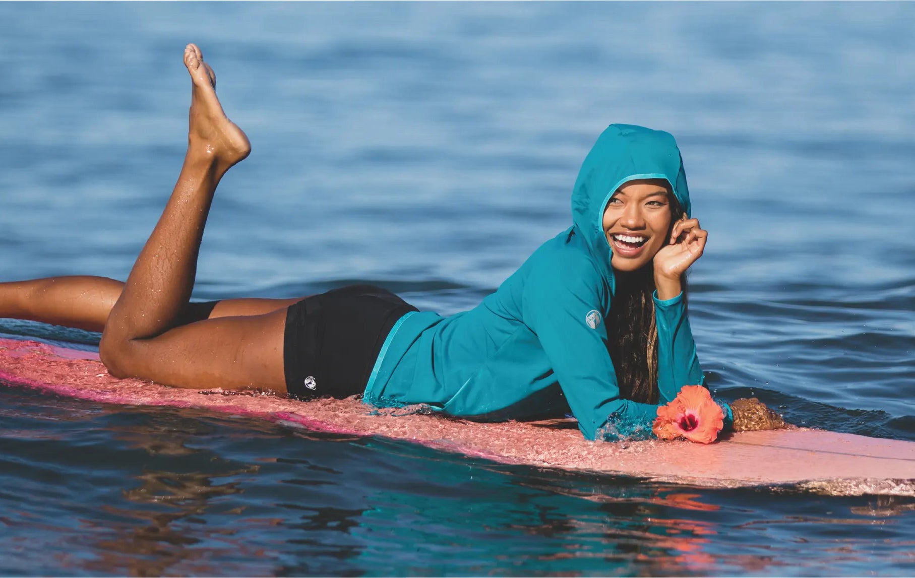 A person lounges on a surf board on a body of water