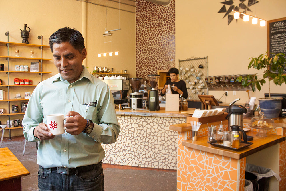 A person enjoys a cup of coffee in a cafe setting