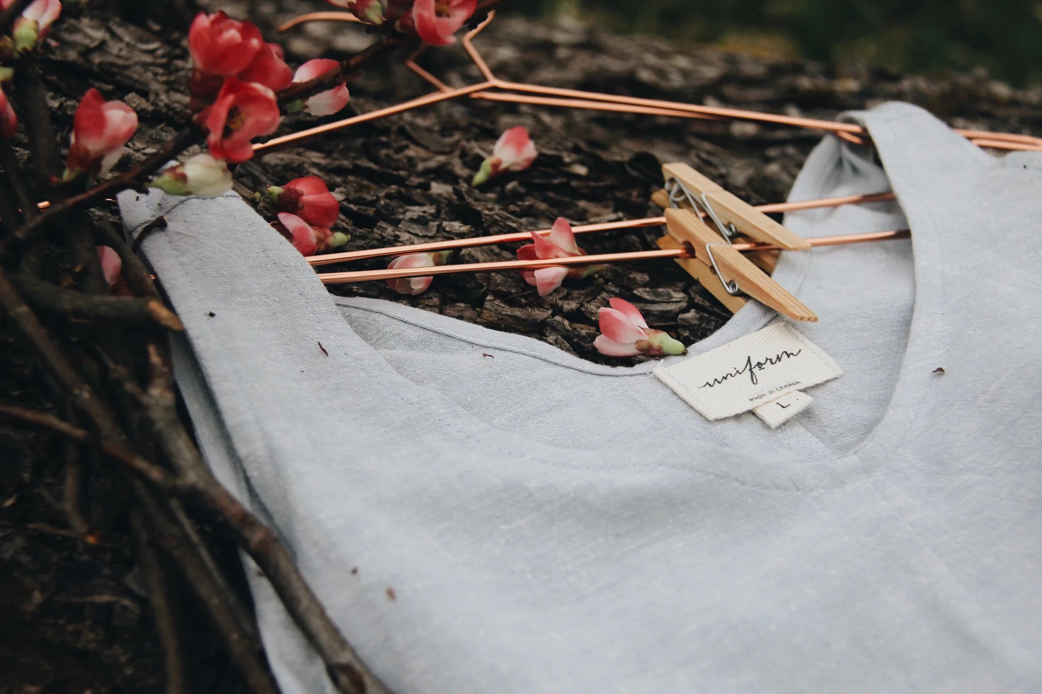 Close up detail of the neckline of a linen tank top laying on a natural surface