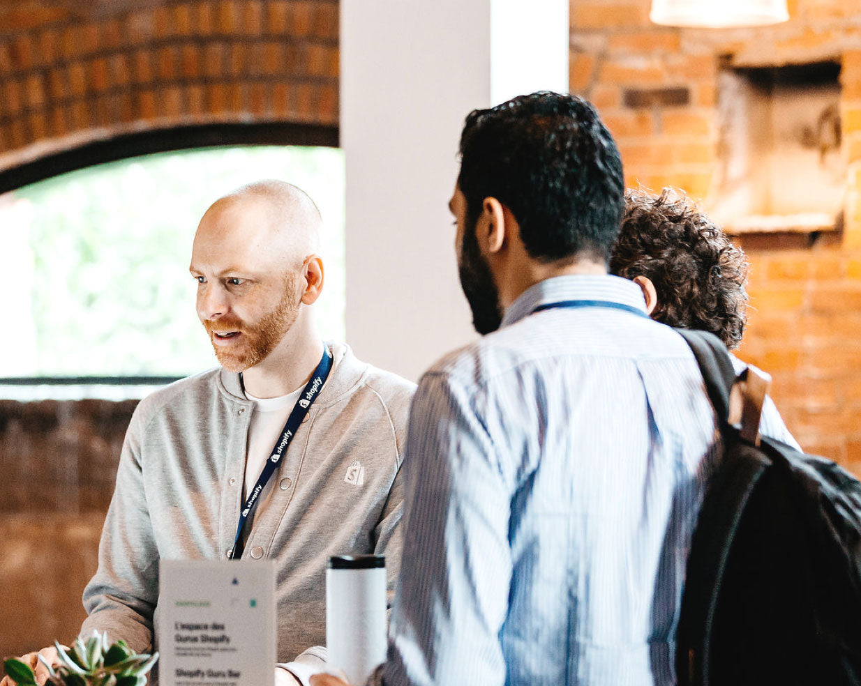 Un empleado de Shopify hablando con dos posibles emprendedores.